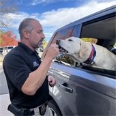 Det.  Tony Costarella gives a dog a treat during Drug Take Back Day
