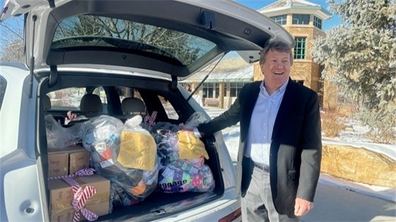 Mayor Lantz poses next to resident Susie Roy’s car full of sock donations. Her neighbors in Cherry Creek Village North helped collect 2,047 pairs of socks.