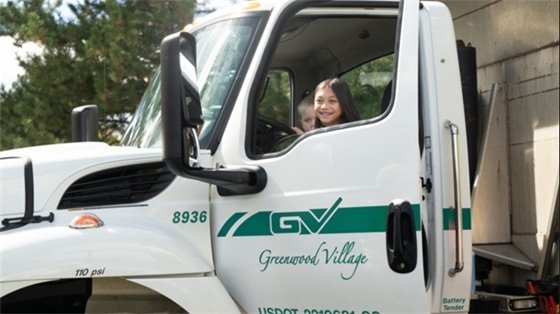 Two children sit in Greenwood Village city truck.