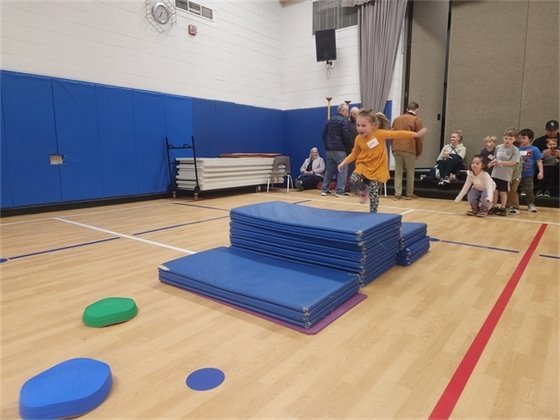 Gril jumping over obstacle at Pee Wee Game Night