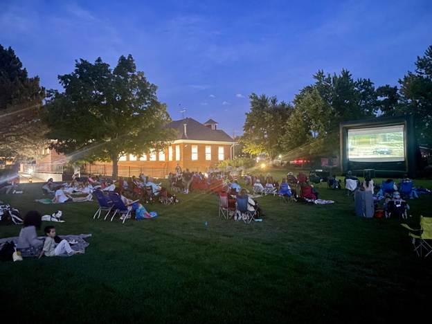 Audience watches an outdoor movie on the grass